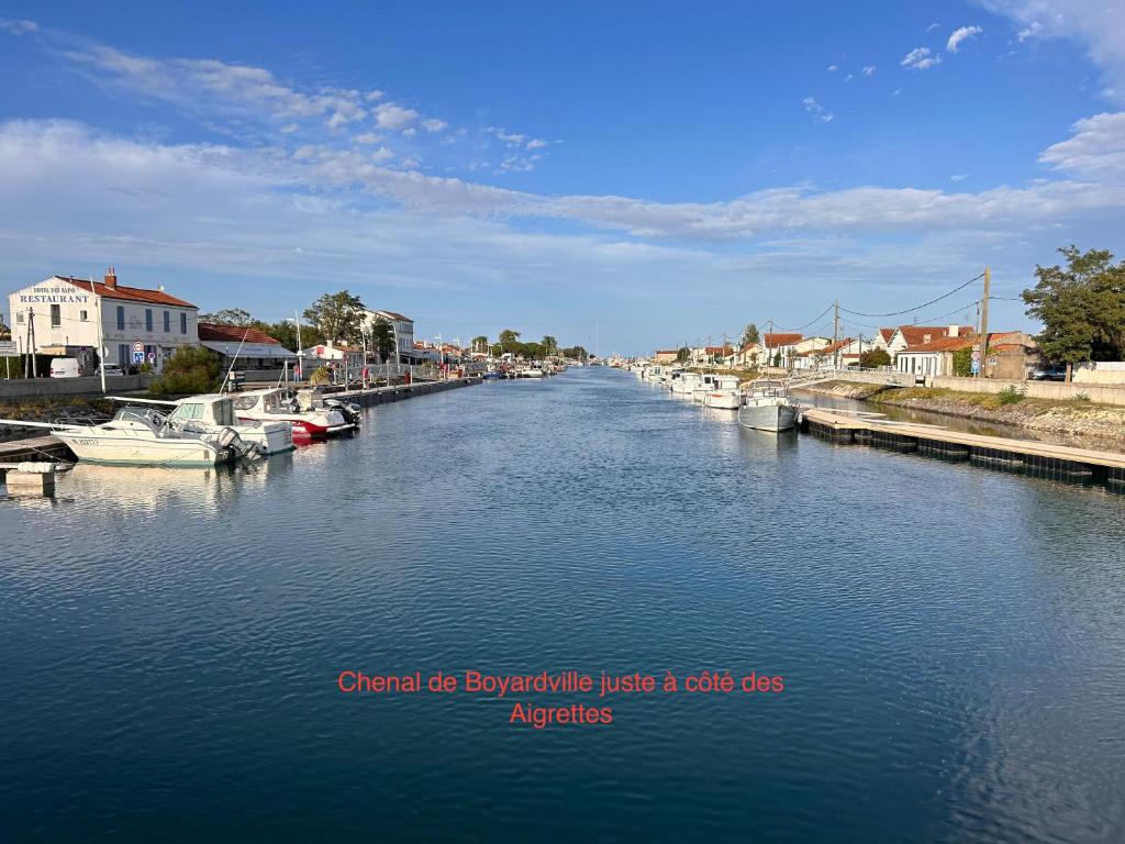 une rivière avec des bateaux amarrés dans une petite ville dans l'établissement Les aigrettes, à Saint-Pierre-dʼOléron