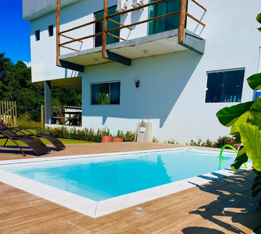 a swimming pool in front of a house at Sunshine - Casa de praia em Barra Grande -Ba in Barra Grande