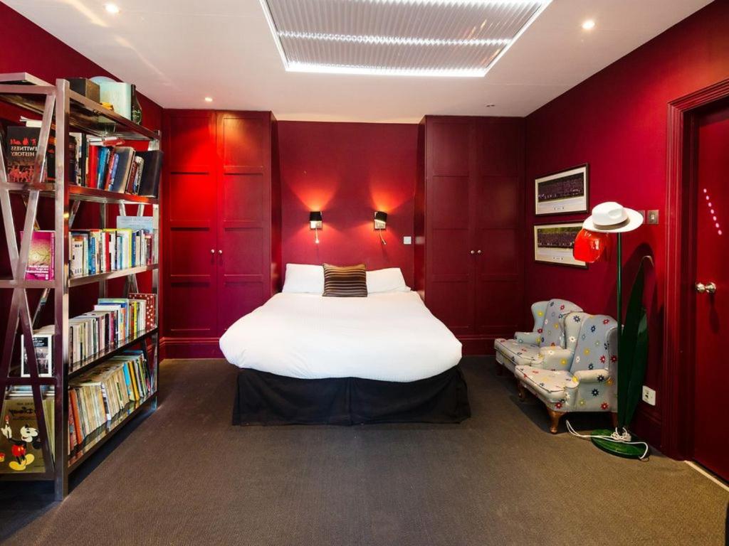 Cette chambre rouge comprend un lit et une étagère. dans l'établissement Charmante maison familiale avec jolie vue mer, à Villeneuve-Loubet