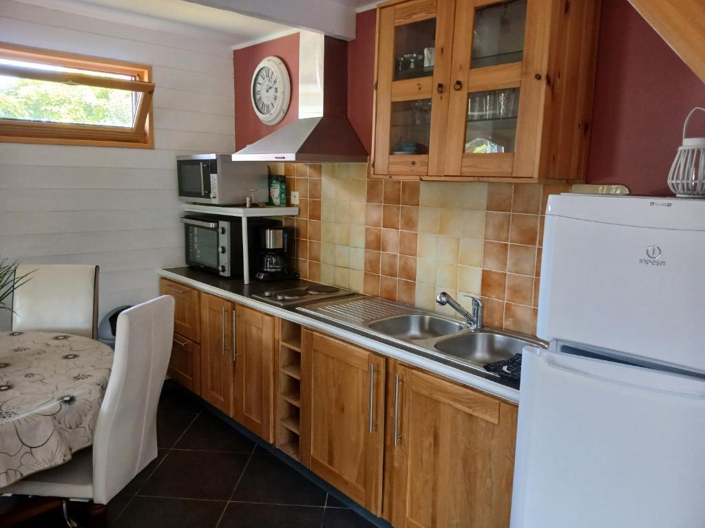 une cuisine avec un évier et un réfrigérateur dans l'établissement Le Chalet de Gonnehem, à Gonnehem