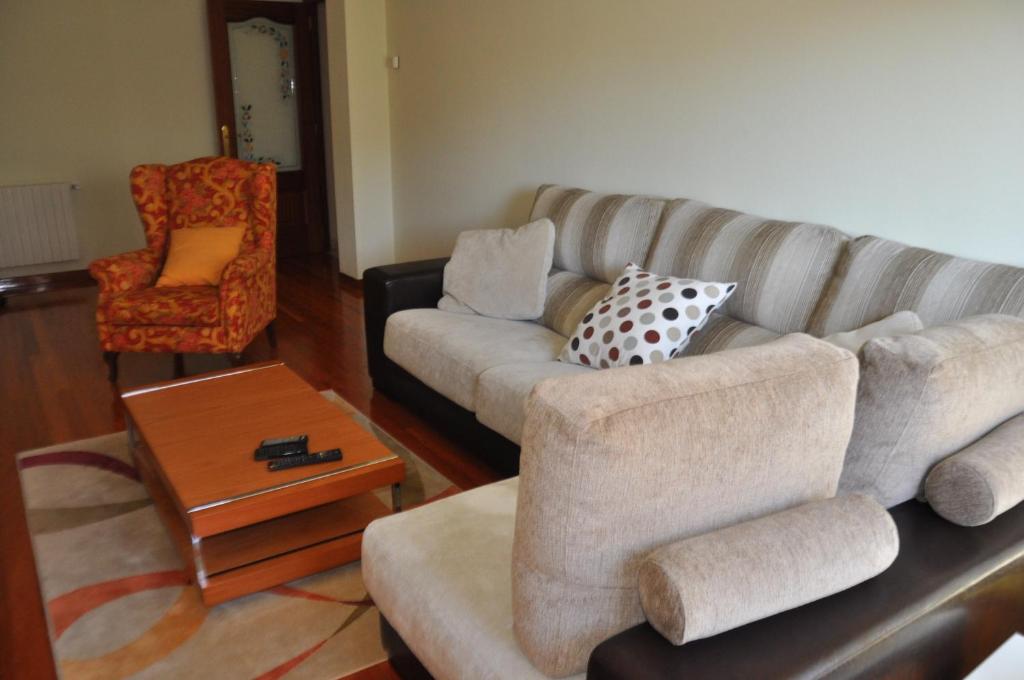 ein Wohnzimmer mit einer Couch und einem Sessel in der Unterkunft Katxutxa El corazon de Galicia in Lalín