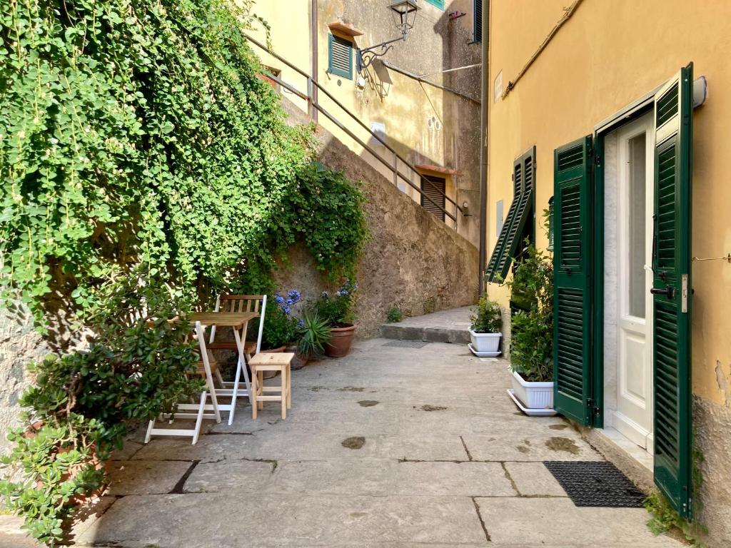 an alley with chairs and a door and a building at Appartamento I Canali in Rio nellʼElba