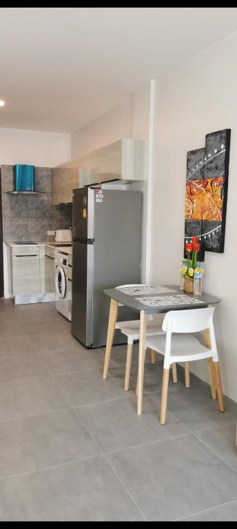 a kitchen with a table and a refrigerator at Super View in Pattaya South