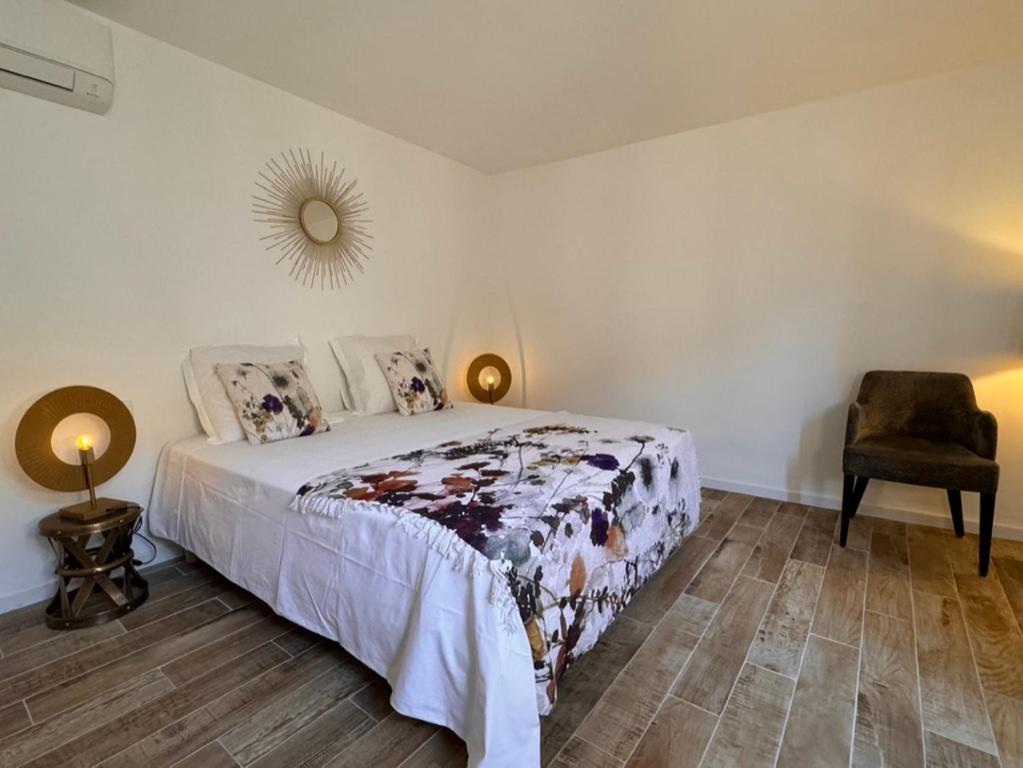 une chambre avec un lit et une chaise dans l'établissement Le Buisson Caché, à Buisson