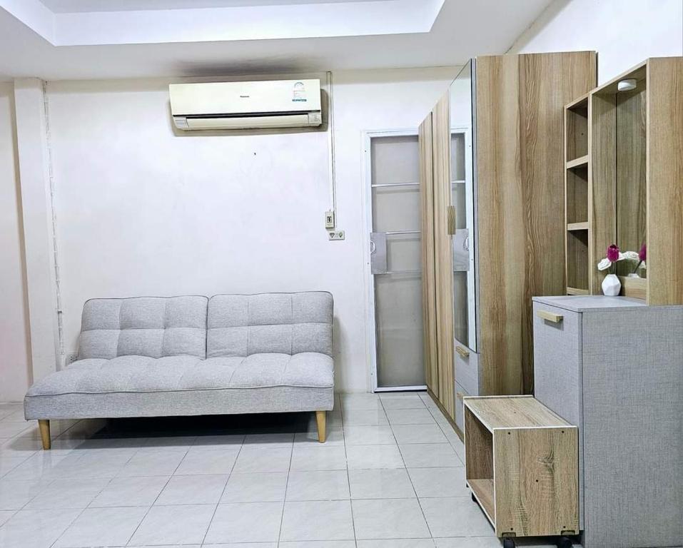 Una sala de estar con un sofá y un refrigerador. en K T Greenvill, en Ban Khom