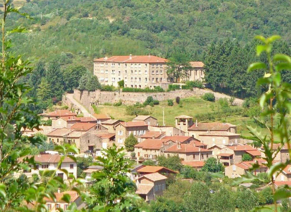 a group of houses on a hill with a large building at Maisonnette à la campagne in Colombier-le-Jeune