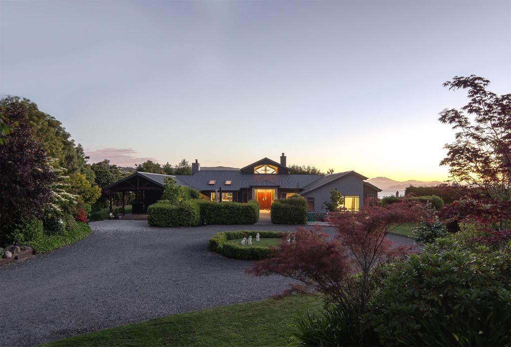 a house with a driveway in front of it at Ruru Lodge - Bed and Breakfast in Kinloch
