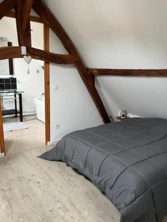 une chambre avec un lit dans une pièce dans l'établissement Gîtes la rivière des îles, à Ponthoile