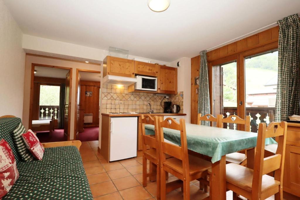une cuisine et une salle à manger avec une table et des chaises dans l'établissement Résidence Le Saint Georges - Saint-Georges 07 MAE-6405, aux Houches