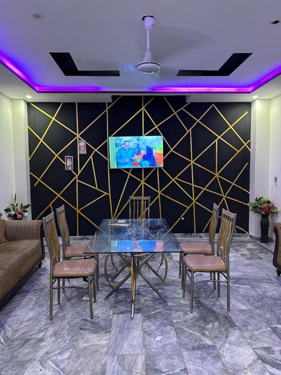 a dining room with a glass table and chairs at The Luxury Girls Hostel- LDA Avenue in Lahore