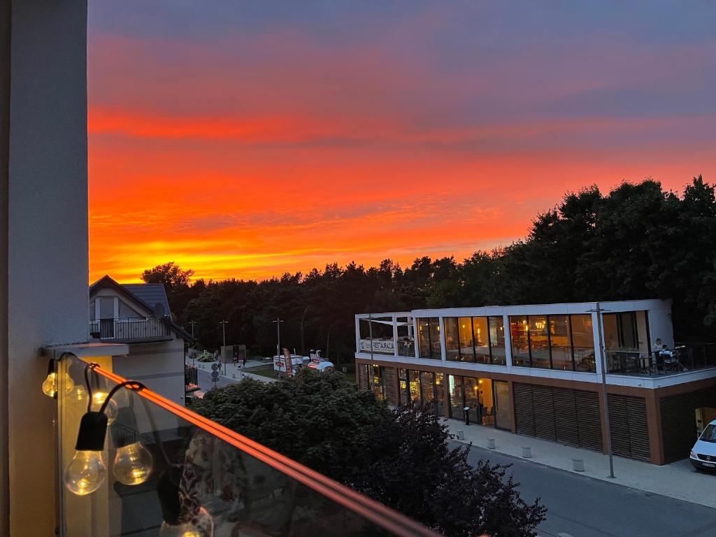 puesta de sol desde el balcón de un edificio en Apartament przy plaży, en Władysławowo