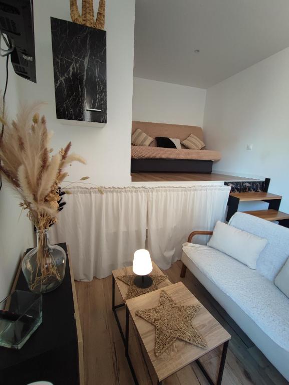 un salon avec un canapé et un lit dans l'établissement Charmant Studio Climatisé plein centre d'Aubagne, à Aubagne