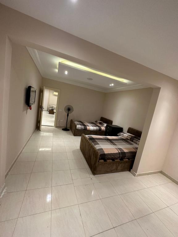 a large room with two beds and a tv at شقه بالمهندسين أول سكن لأصحاب الذوق الرفيع in Cairo
