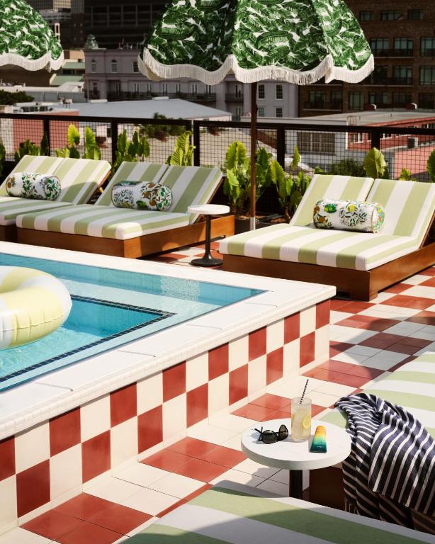 a pool with chaise lounges on the roof of a building at Memoir Warehouse District in New Orleans