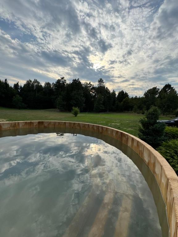a pool of water with a wooden bridge at Miejsce w lesie in Stara Huta