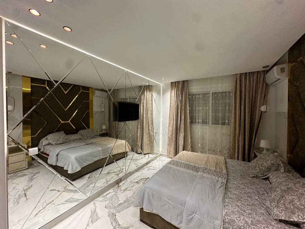 a bedroom with two beds and a large mirror at Mandri apart in Tetouan
