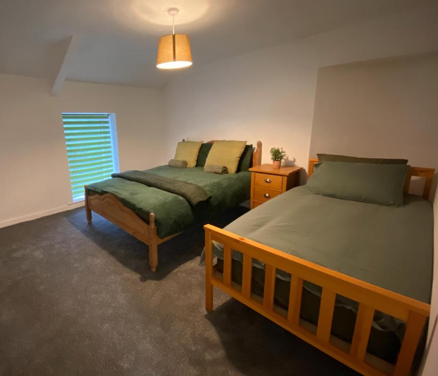 a bedroom with two beds and a window at Lime Cottage in Mountain Ash