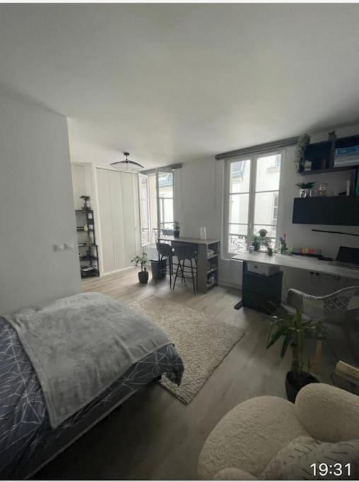 une chambre avec un lit et un bureau dans une pièce dans l'établissement Joli studio Batignolles Paris, à Paris
