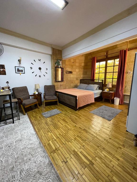 a bedroom with a bed and a clock on the wall at Sunny airport studio New Cairo in Cairo