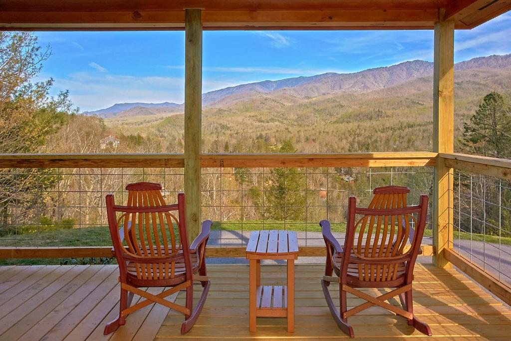 twee stoelen en een tafel op een veranda met bergen bij Bearfoot Memories Holiday home in Gatlinburg