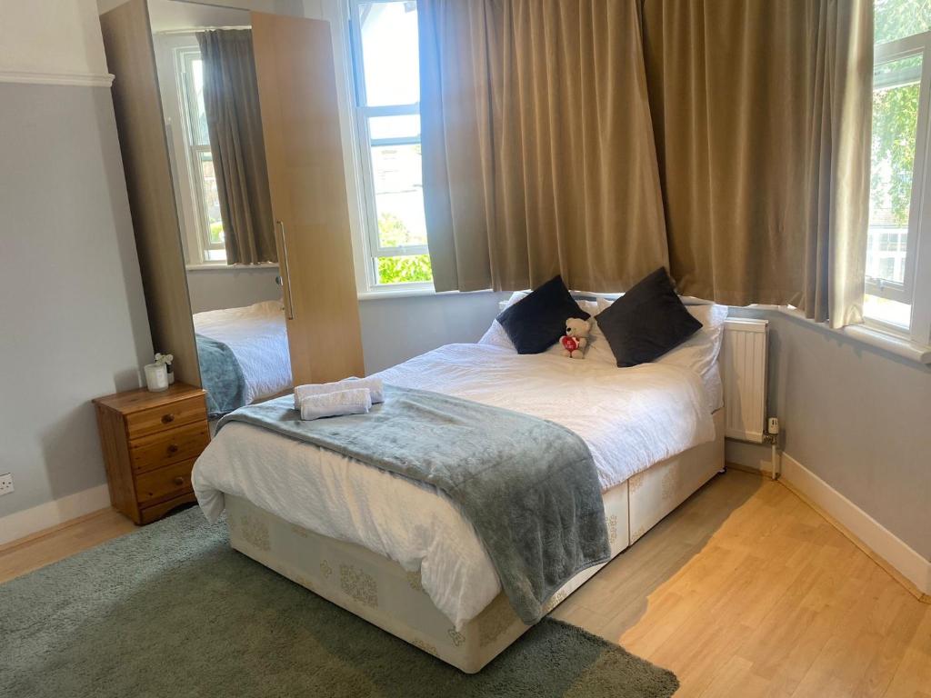a bedroom with a bed with a teddy bear on it at Cranley in Carshalton
