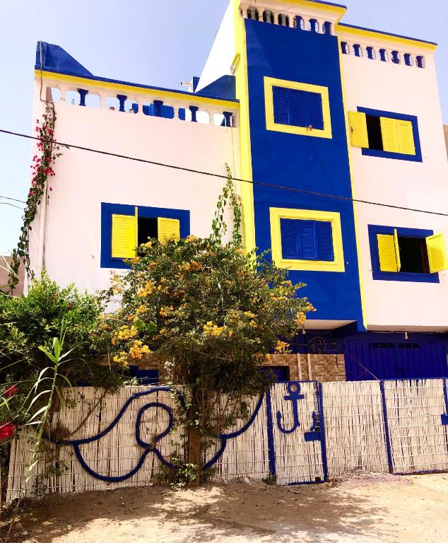 a blue and white building next to a fence at Ocean Desert Spirit in Akhfennirr