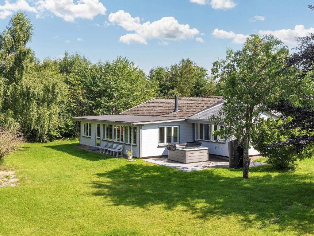 a white house in a yard with a tree at 4 star holiday home in Gedsted-By Traum in Gedsted