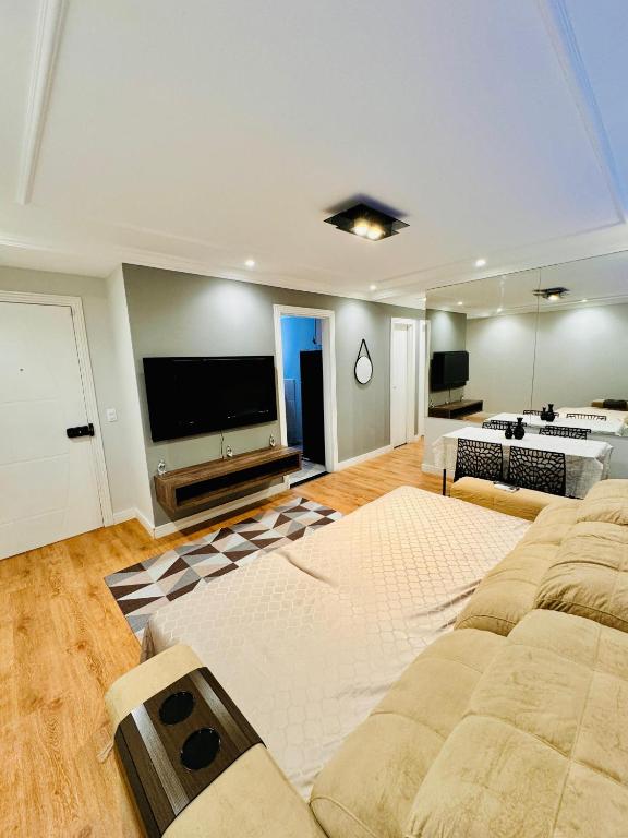 a large living room with a large flat screen tv at Apto 3 quartos, garagem, ar condicionado in Londrina