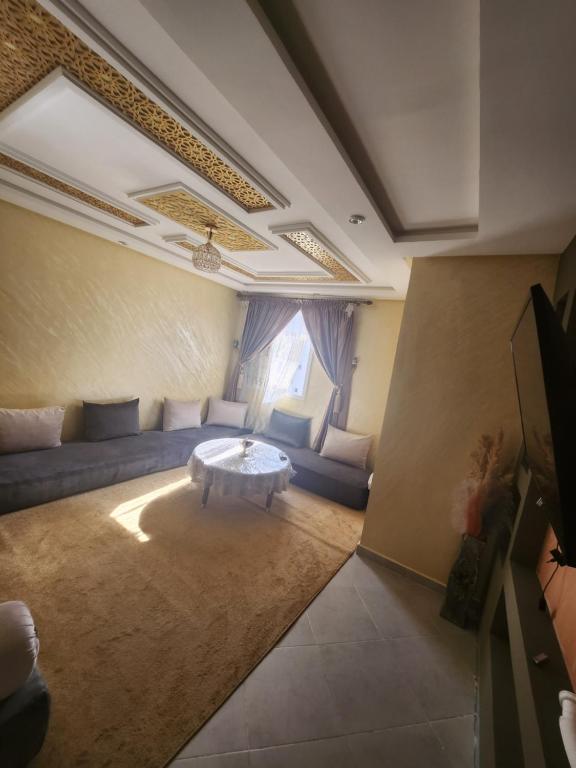 a living room with a couch and a table at Agadir anza résidence miftah sahil in Agadir
