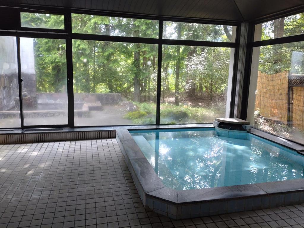 Una gran piscina en un edificio con ventanas. en Hotel Kosho, en Nikko