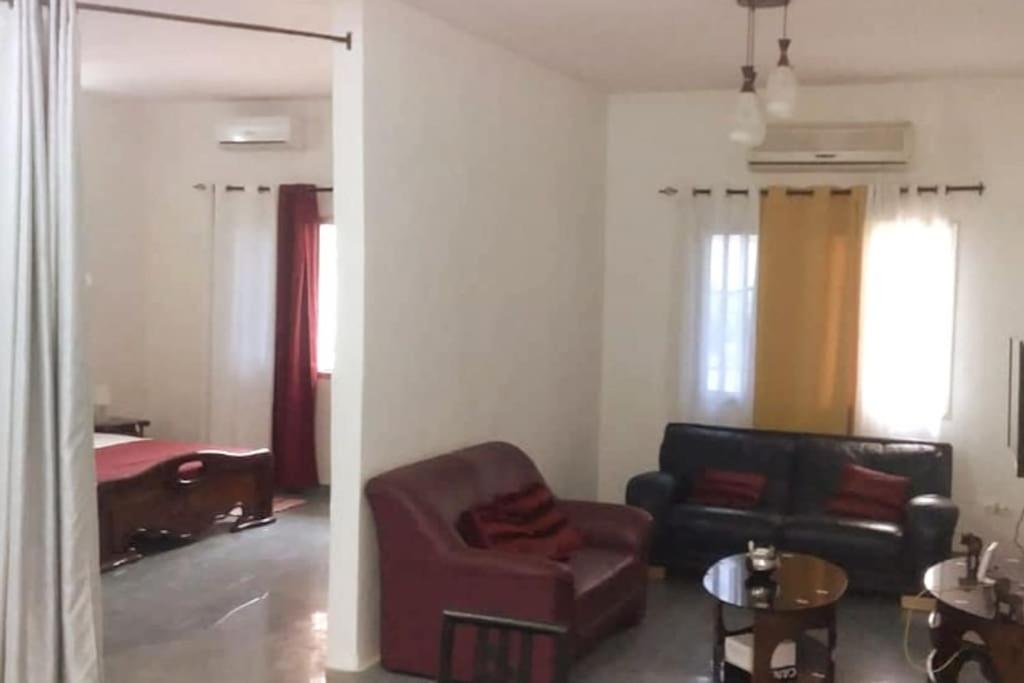a living room with a couch and a chair at Grand studio climatisé 5' mer accès Dakar in Dakar