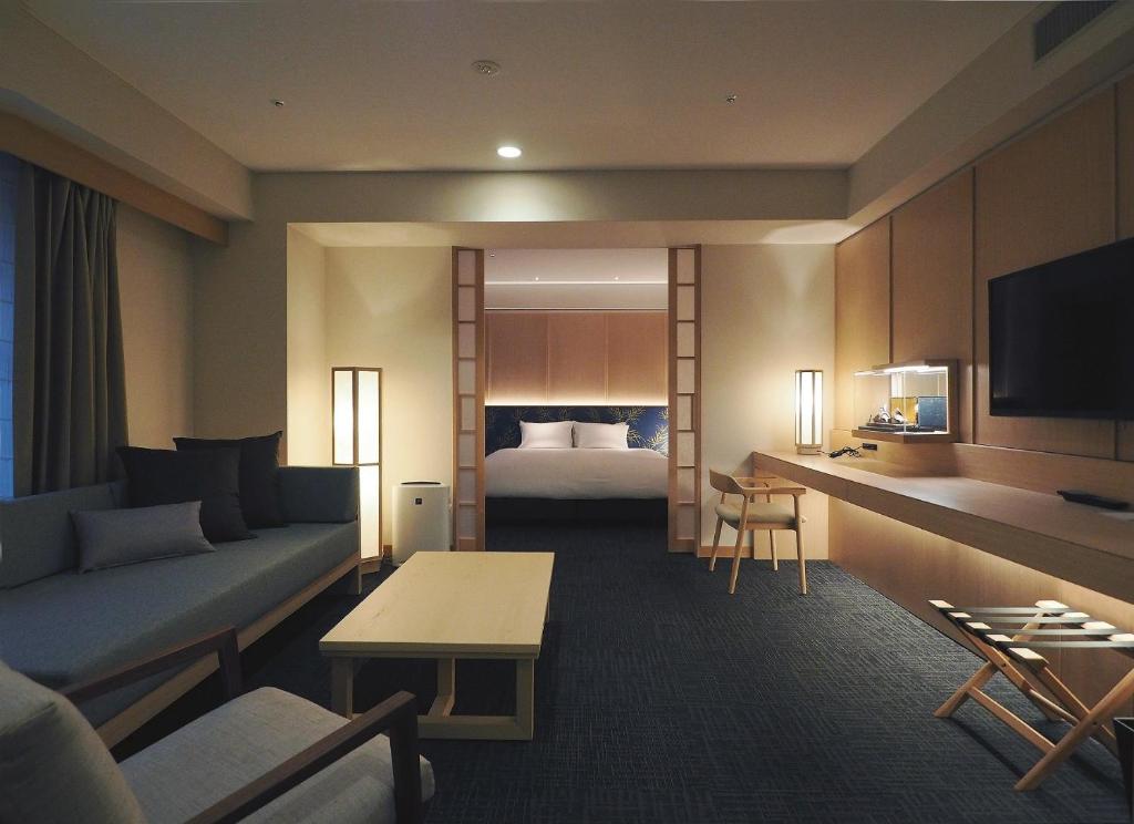 a hotel room with a couch and a bed at Noku Kyoto in Kyoto