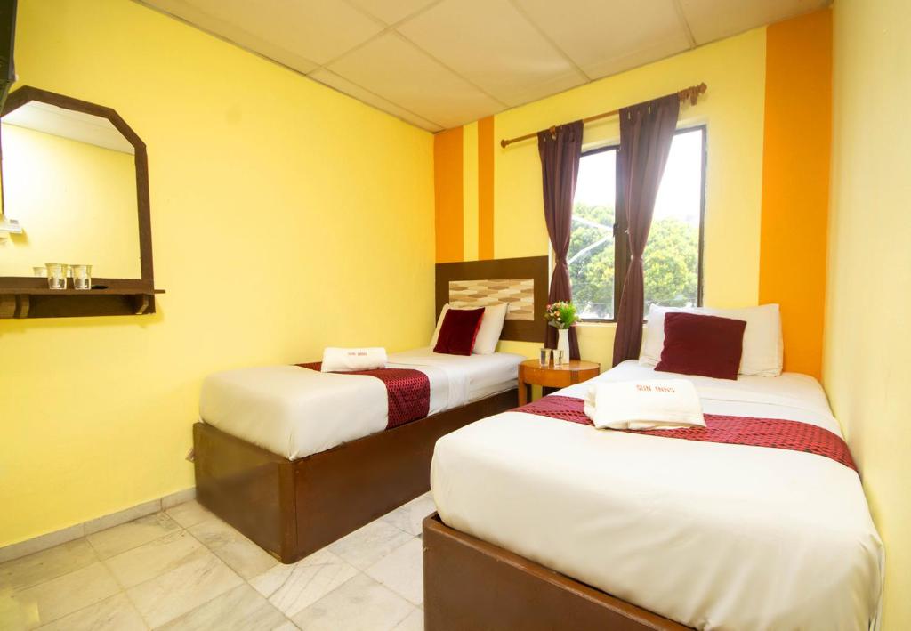 Postel nebo postele na pokoji v ubytování Sun Inns Skudai