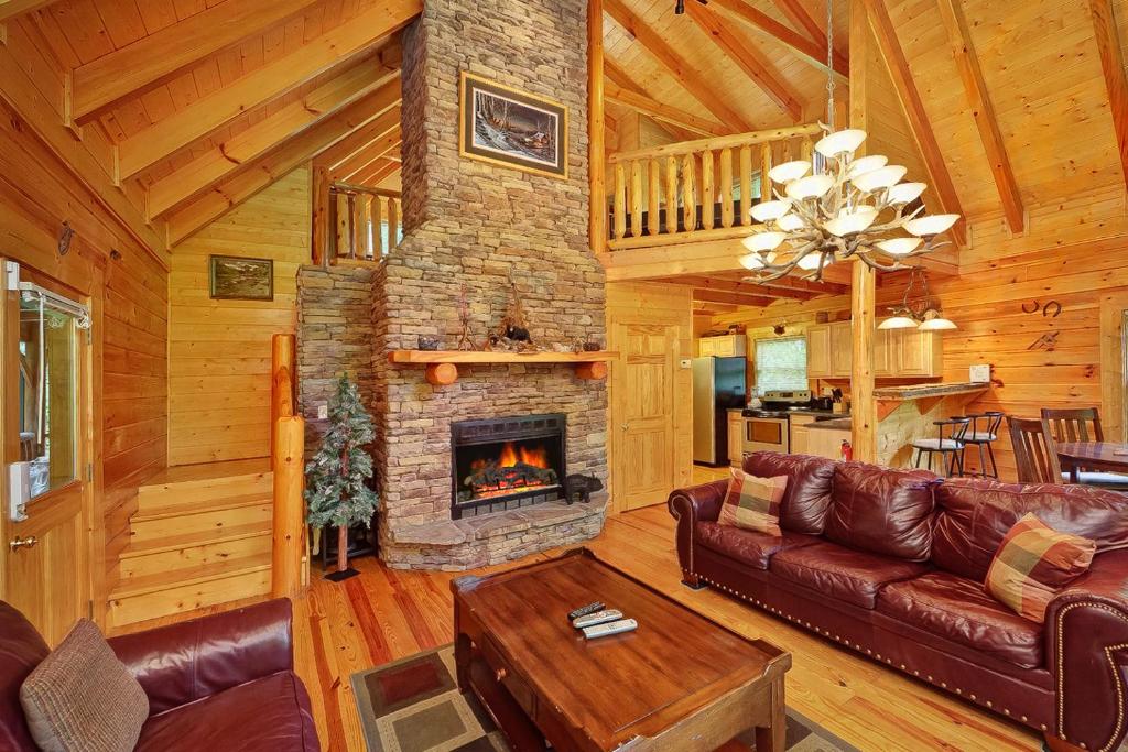 ein Wohnzimmer mit Kamin in einer Blockhütte in der Unterkunft Magic Moments Holiday home in Gatlinburg