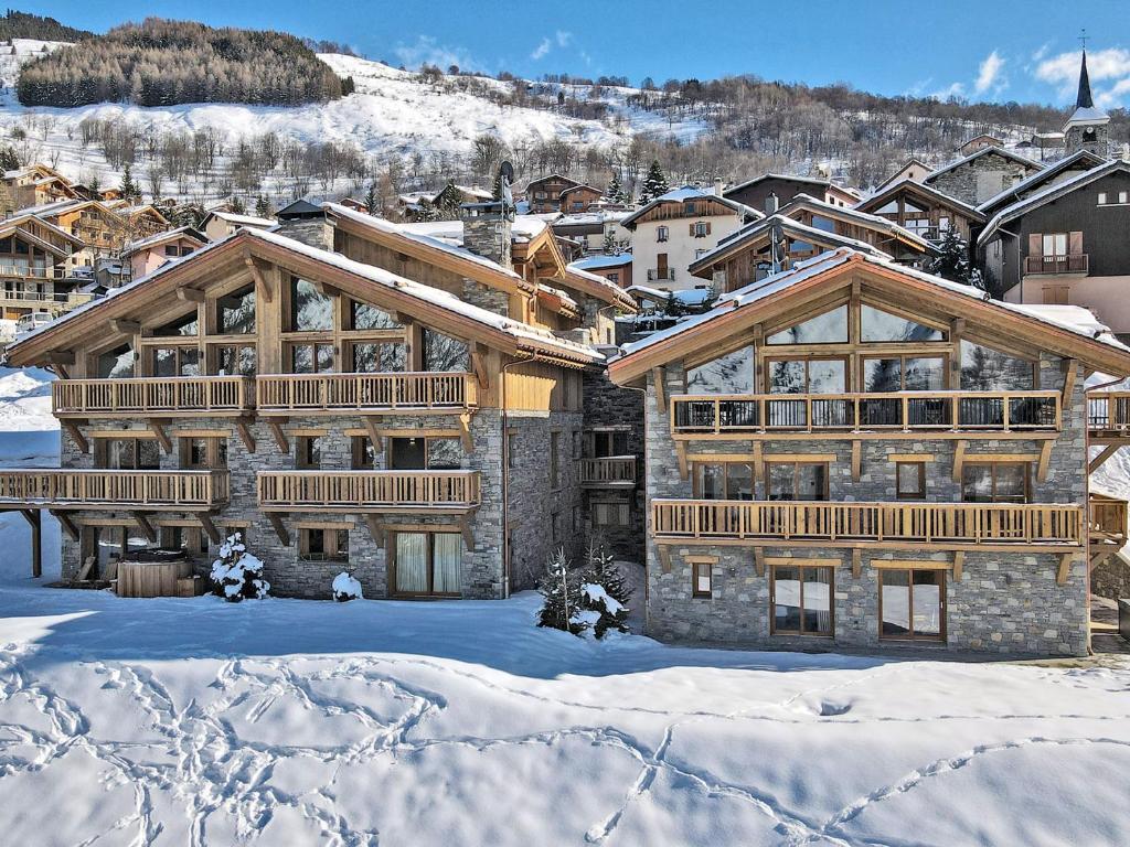 un grand bâtiment avec de la neige au sol dans l'établissement Appartement de standing, 8 pers, 3 chambres, balcon, cheminée, au cœur de Saint Martin de Belleville - FR-1-613B-11, à Saint-Martin-de-Belleville
