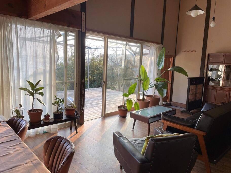 a living room with a large window and plants at Holiday house with great views! in Kariya