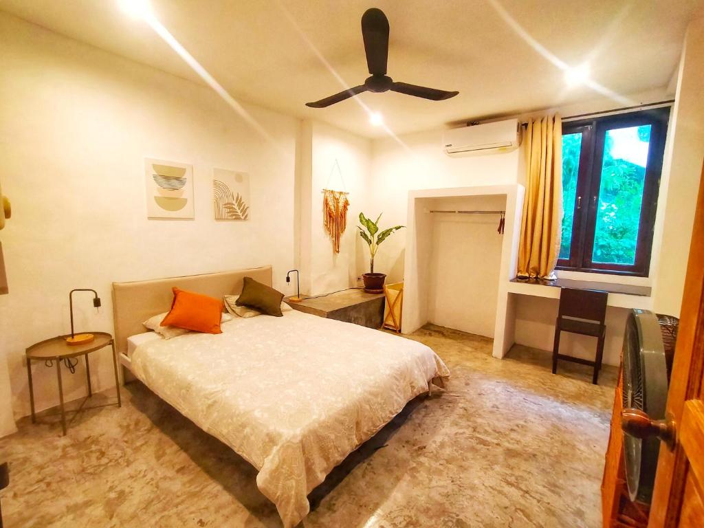 a bedroom with a bed and a ceiling fan at Koh Tao -Tropical Apartments in Koh Tao