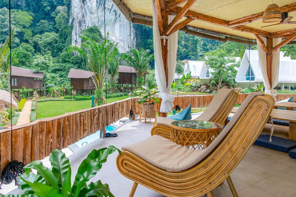 a patio with chairs and a table on a fence at Voasis Valley Krabi - Natural Resort - Adults Only in Ban Nong Kok (1)