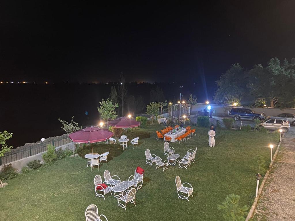 a group of chairs and tables in a yard at night at Hotel Blangsa Indus View in Skardu