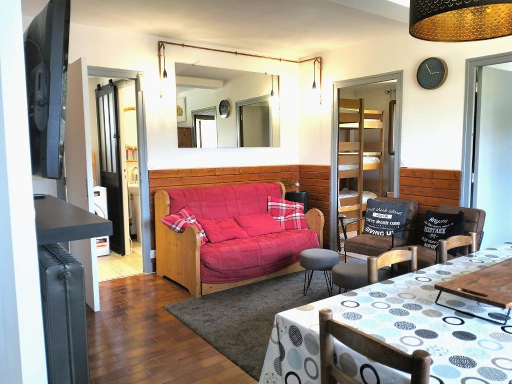 un salon avec un canapé rouge et une table dans l'établissement Charmant 3 pièces: balcon, parking privé, proche village - FR-1-761-42, à Villard-de-Lans