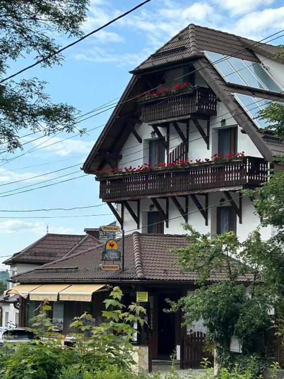 a building with a balcony and flowers on it at Bran Pensiunea Restaurant Al Gallo centru in Bran