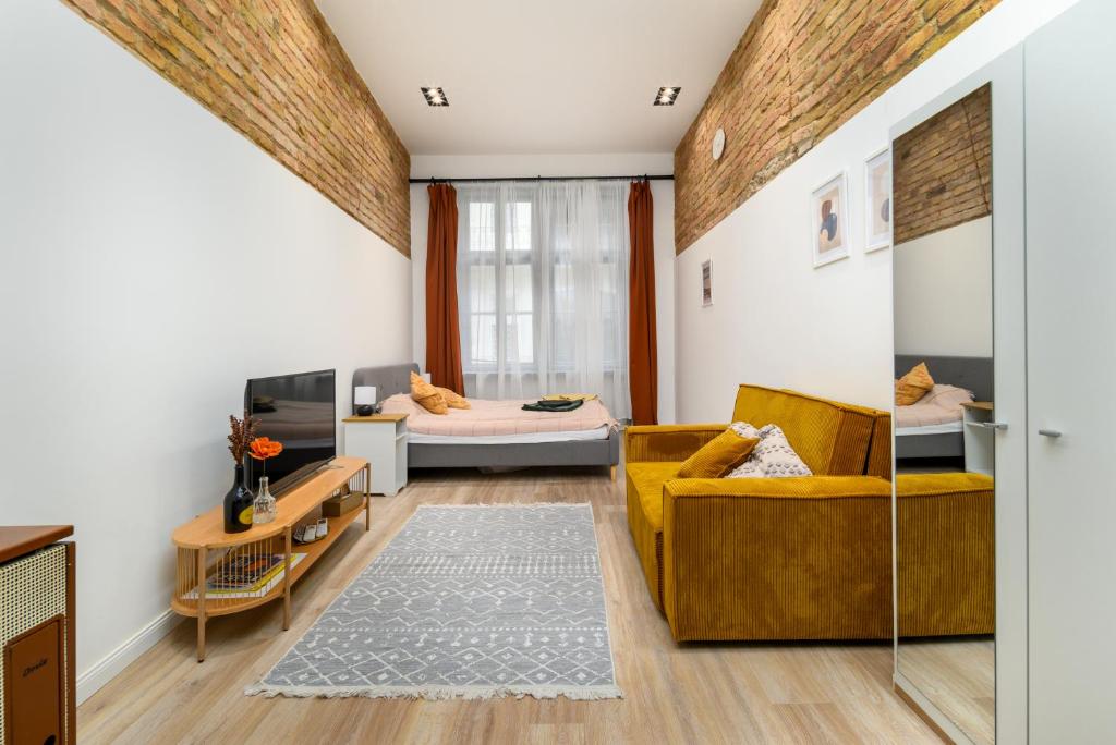 a living room with a yellow couch and two beds at Downtown apartment 2 minutes from Opera House in Budapest