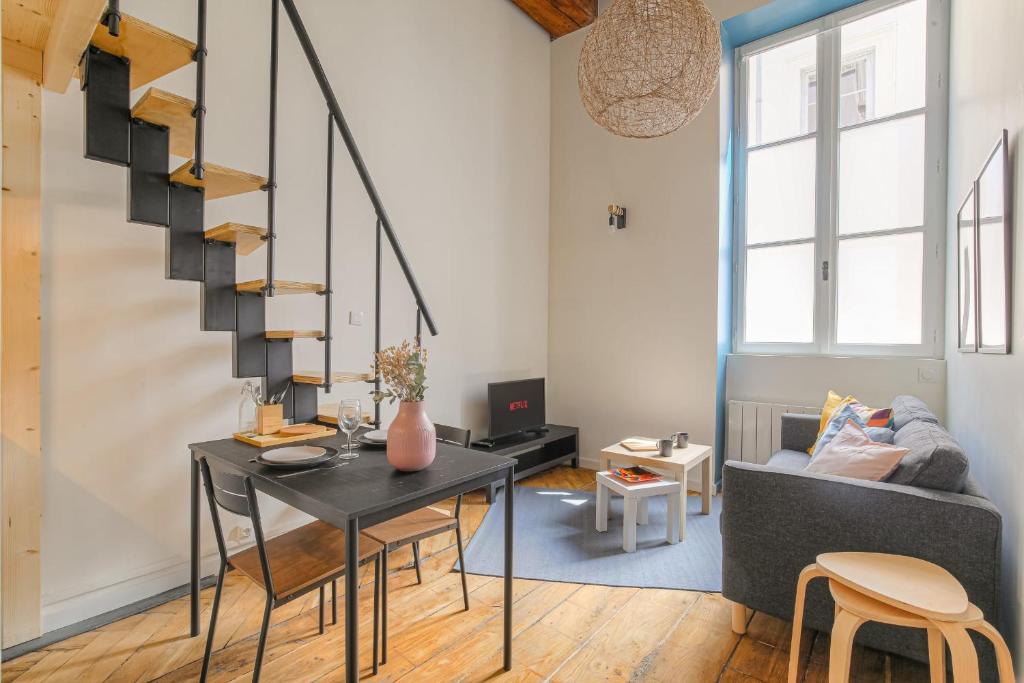 un salon avec une table et un escalier dans l'établissement Atypique et Cosy Hôtel de Ville et quais du Rhône, à Lyon