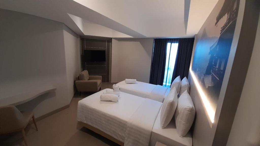 Postel nebo postele na pokoji v ubytování Nemuru Grand Suites