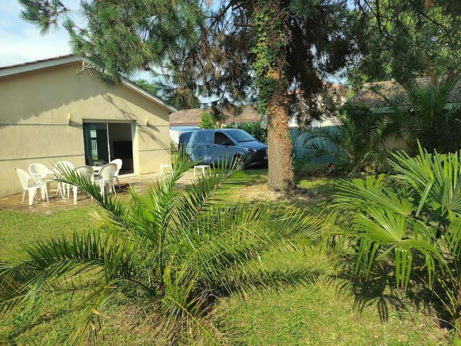 a house with a car parked in a yard at Maison 4 chambres in Eysines