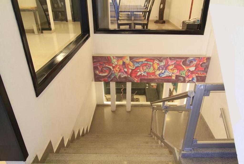 uma escada com um banco com uma pintura em Rainbow Residency em Nova Deli