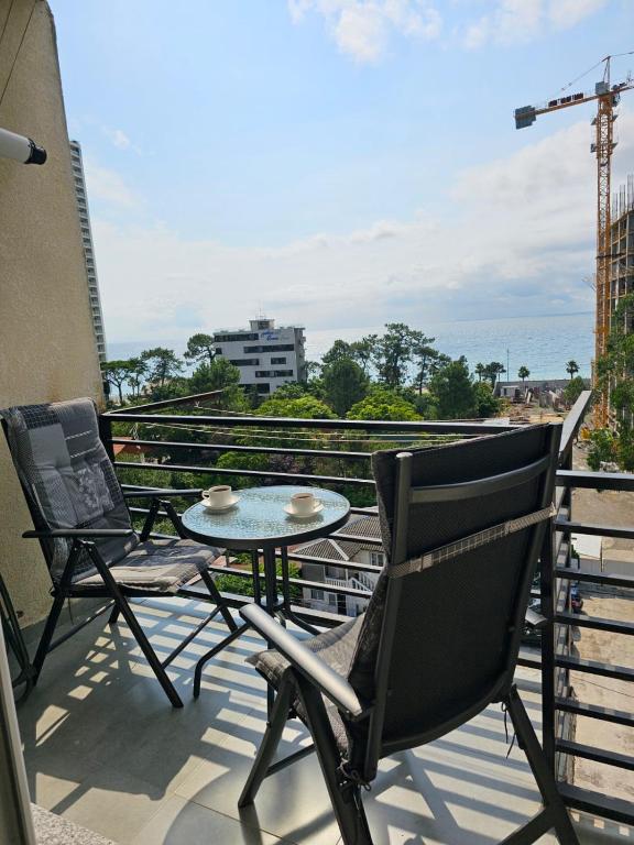 a patio with two chairs and a table on a balcony at Gonio Apartment Seaview in Kvariati