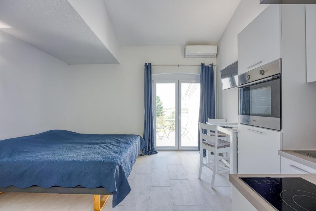 a bedroom with a bed and a television and a desk at Apartments Galeb in Poreč