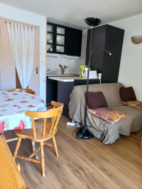 - un salon avec un lit, une table et une lampe dans l'établissement Studio Cabine Pied de Piste La Mongie, à Bagnères-de-Bigorre