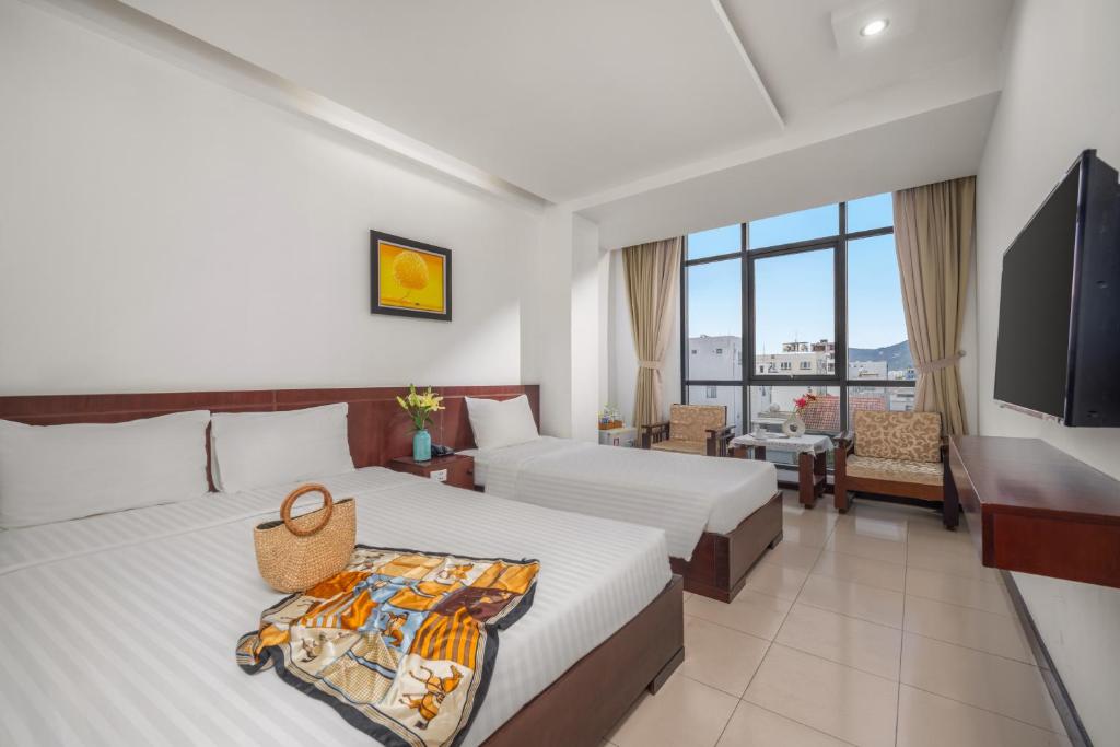 a hotel room with two beds and a television at Star Hotel and Spa Danang in Danang